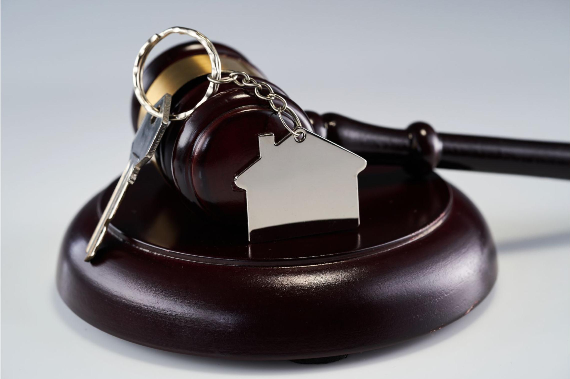 An auction gavel with a door key and keychain