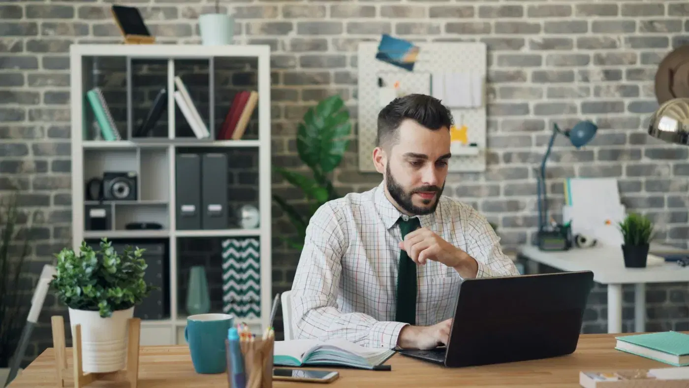 A man working through documents at his laptop